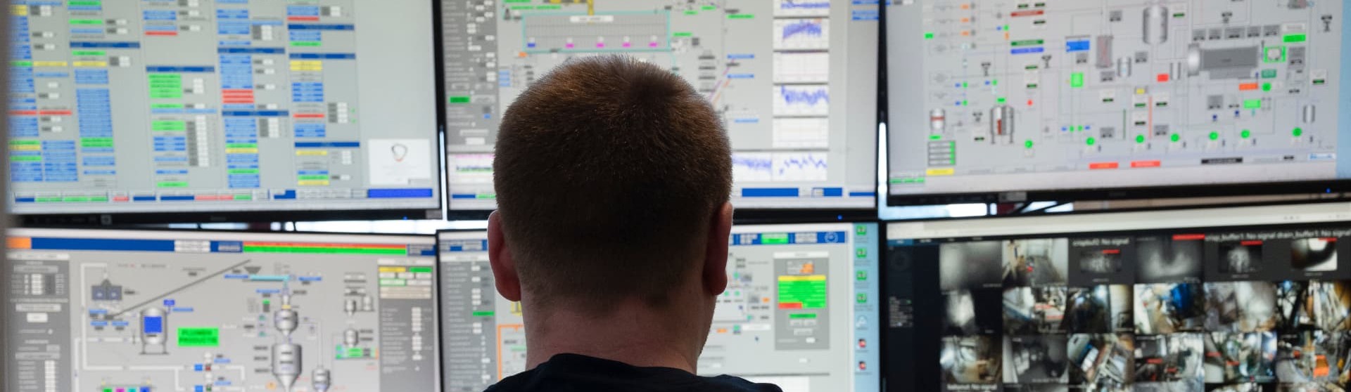 Een medewerker van Empro bekijkt in de controlekamer zes schermen met procesgegevens en camerabeelden